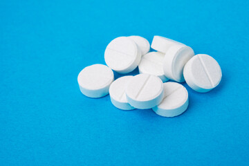 Round white medcine pills antibiotic on blue background textured