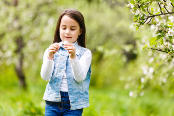 Portrait beautiful little girl near blossoming apple-tree.