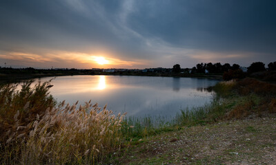 Idyllic orange sunrise big sun and twilight sky at the lake. End of day