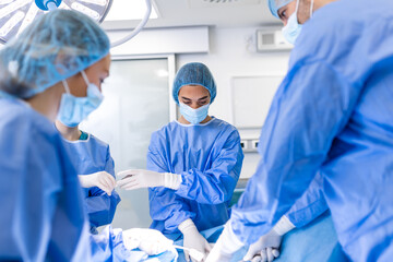 Shot in the Operating Room, Assistant Hands out Instruments to Surgeons During Operation. Surgeons Perform Operation. Professional Medical Doctors Performing Surgery.