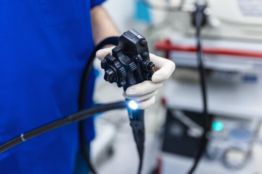 Doctor proctologist holding endoscope during colonoscopy. Probe colonoscope. Doctor gastroenterologist with probe to perform gastroscopy and colonoscopy