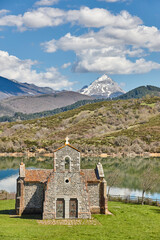 Picturesque chapel of Quintanilla in Riano mountain lake landscape. Spain