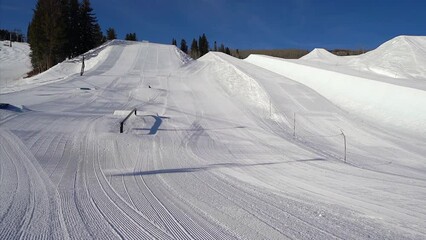 X Games Half Pipe ski snowboarding terrain park rail fresh groomed bluebird sunny morning bottom of Buttermilk opening chairlifts Aspen Colorado slider movement left