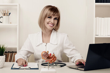 Young beautiful doctor woman working happy and smile in hospital, sitting on table, mockup stomach...