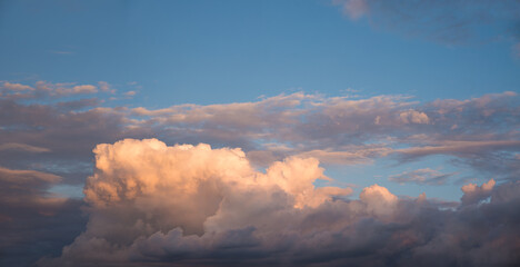 heap of lighted cumulus cloud and blue sky above, sunset scenery