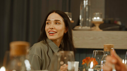 Close up shot of woman eating and enjoying tasty dish, talking with friends in modern gastro cafe. She celebrates birthday, has family dinner, spends evening in restaurant. Concept of public catering.