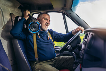 Professional driver driving a truck on the road listening to music and having fun.