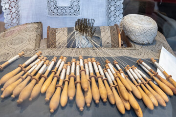 Bobbin lace. Close-up of a table dedicated to the beautiful craft of weaving threads,.