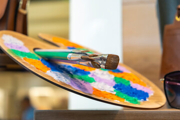 Wooden art palette of oil paints and brushes