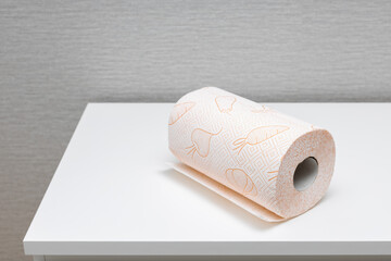a roll of paper towel lies on a white table.