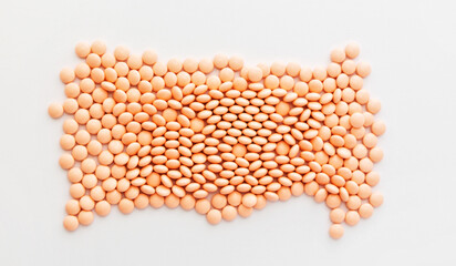 Pink pills in the shape of heart on white background. Vitamins, supplements for the heart. 