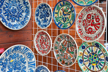 Traditional romanian handmade ceramic pottery plates with rustic authentic decoration paintings on display.