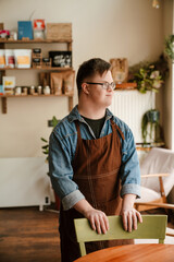 Man with down syndrome smiling while working in cafe