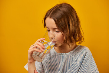 Pretty teen girl, child with a fresh glass of water isolated