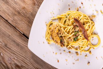 Piatto di Spaghetti con aglio, olio, peperoncino e tarallo napoletano sbriciolato servito come primo piatto in un ristorante