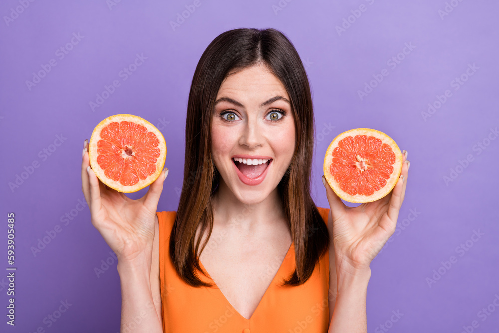 Sticker Photo of cute astonished girl open mouth arms hold two slices grapefruit isolated on violet color background