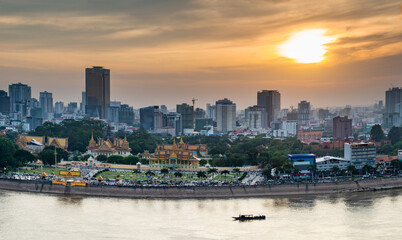 Phnom Penh river cruise boat passing the Royal Palace,at sunset,Cambodia.