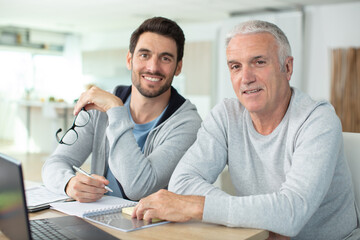 two men in making plans together at table at home