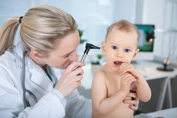 otolaryngologist checking babys ear with otoscope