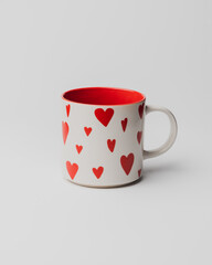 White empty cup with red hearts on white background.  