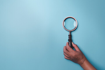 Magnifying glass on blue background. Top view. Flat lay. Copy space. Minimal creative concept. Blue background in pastel colours