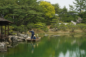 Fototapeta na wymiar Traditional Japanese Boat on Pond and Japanese Garden at Ritsurin Garden Park in Takamatsu, Kagawa, Japan - 日本 香川 高松 栗林公園 日本庭園 池 和船