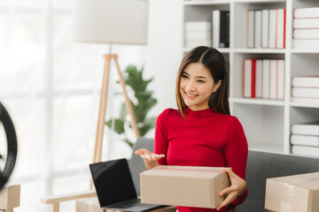 Starting Small business entrepreneur SME freelance,Portrait young woman working at home office, BOX,smartphone,laptop, online, marketing, packaging, delivery, SME, e-commerce concept