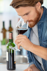 handsome young man smelling red wine