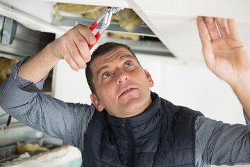 young man repairing ceiling