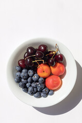 Organic ripe berries and fruits in the white bowl. Close up