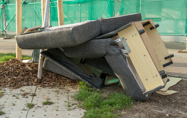 Bulky garbage heap with old upholstered furniture on the side of the road