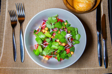 Appetizing tasty fresh tomato salad with capers, onions, parsley and pesto sauce