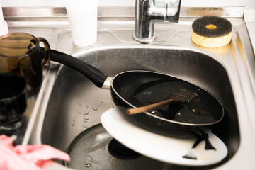 Metal sink full of dirty dishes, crockery, tableware