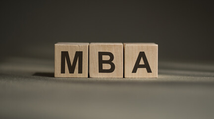 There is wood cube with the word MBA. It is an acronym for Master of Business Administration.