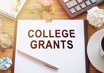 College Grants -text on notebook on office wooden background.