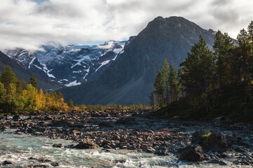 River with a rocky bank against a mountain scenery in Lyngen, Norway