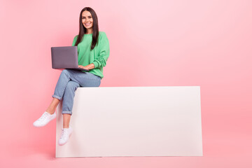 Photo of adorable lovely positive lady wear stylish clothes use netbook speed wifi sit empty space isolated on pink color background