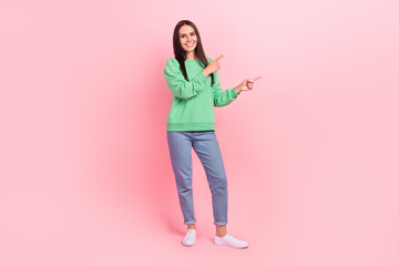 Full length photo of adorable cheerful lady wear green clothes presenting spring collection empty space isolated on pink color background