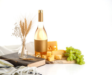 The concept of the Israeli holiday Shavuot. Bottle of wine, cheese slices and grapes on a wooden...