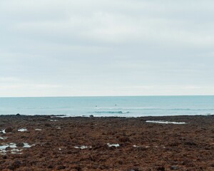 View of the seawater from the coast under the cloudy sky.