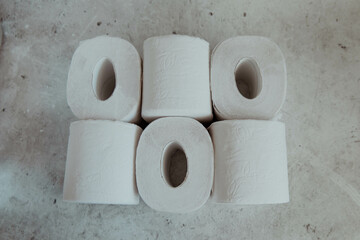 Stack of toilet paper rolls on a gray light background