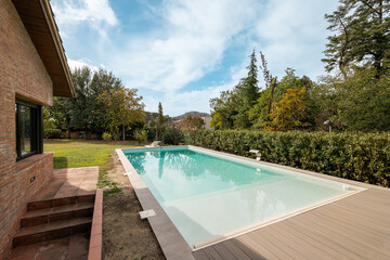Gorgeous view of the backyard of a country house with a swimming pool with clean clear water on a...