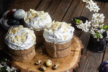 Easter cake with meringue and almond petals on a wooden background