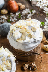 Easter cake with meringue and almond petals on a wooden background