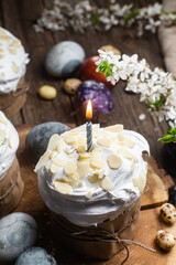 Easter cake with meringue and almond petals on a wooden background