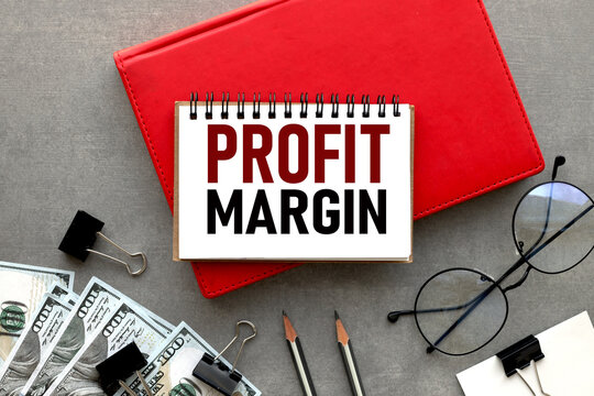 Profit Margin. glasses near the red notepad. text on white pages. Financial concept