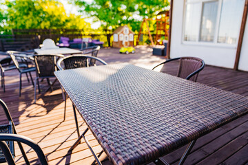 plastic wicker table on the wooden terrace for outdoor dining. a dining room.