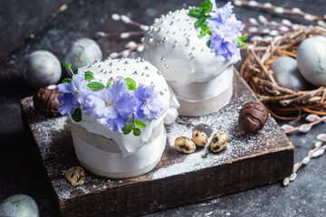 Easter cake with meringue and violets on a dark background