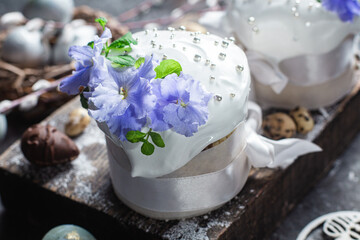 Easter cake with meringue and violets on a dark background