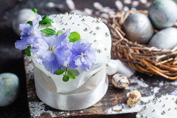 Easter cake with meringue and violets on a dark background